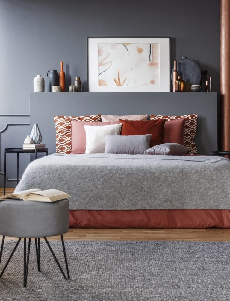 sypialnia z szarymi ścianami i dużym łóżkiem