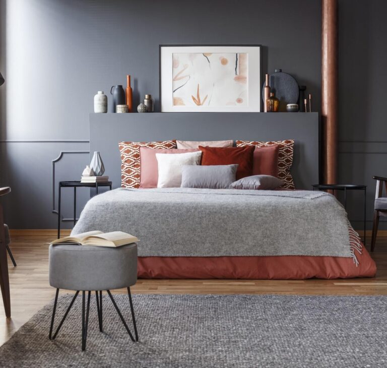sypialnia z szarymi ścianami i dużym łóżkiem